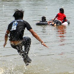 lifeguard in jeans and t-shirt jumping into a lake